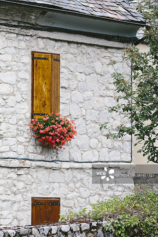 石头外墙，窗户上挂着鲜花图片素材