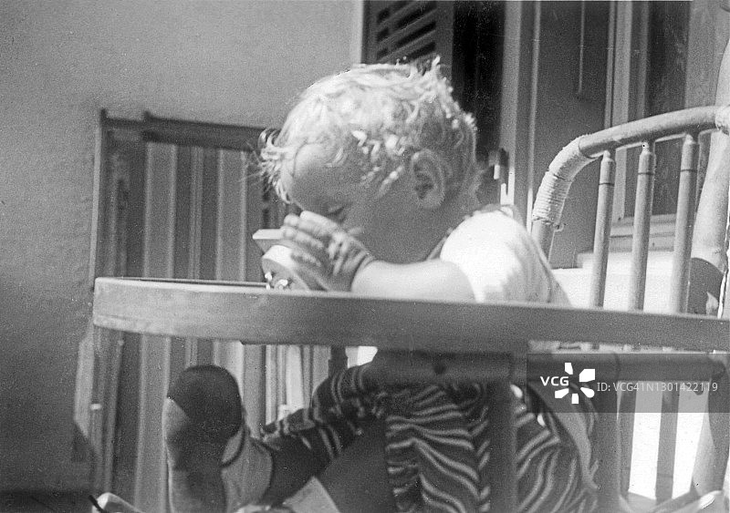 坐在高脚椅上玩玩具的女婴图片素材