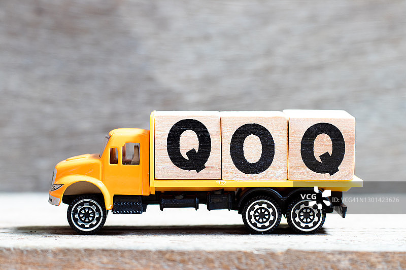 卡车在木纹背景上展示“QOQ”字母积木图片素材