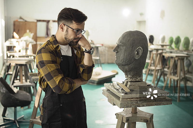 创作黏土半身像的年轻男雕塑家图片素材