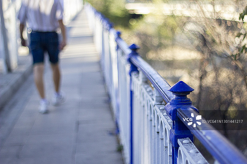 走在萨拉戈萨铁桥上的男子背影图片素材