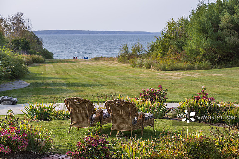 豪华住宅后院夏季花园中的两张柳条躺椅图片素材