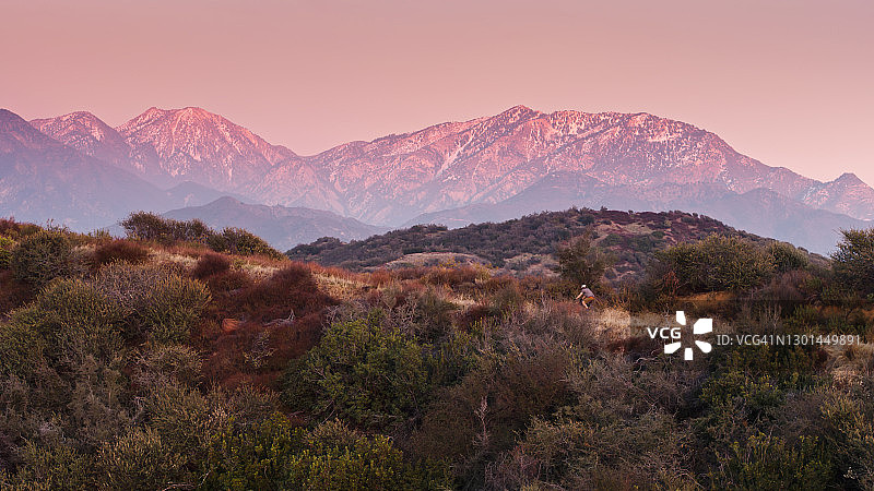 骑自行车的人在雪山小路上骑行 - 航拍图片素材