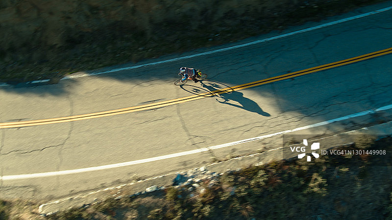 山路上骑自行车的人的影子很长 - 航拍图片素材