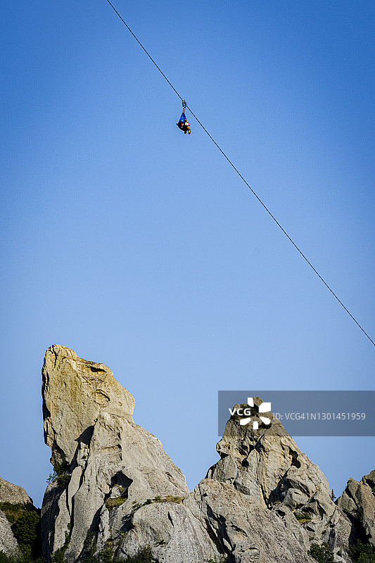 男子在意大利巴斯利卡塔的晴空中玩滑索图片素材