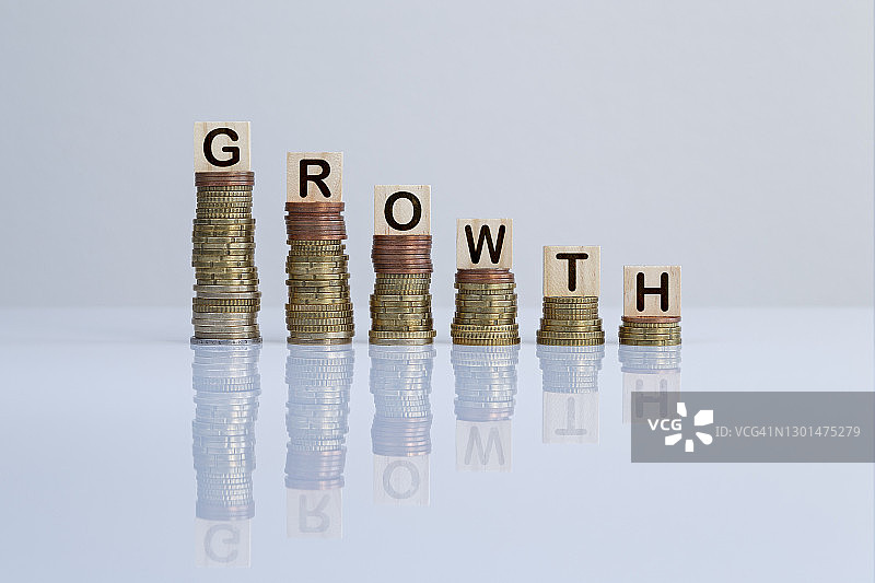 木块上的“增长”字样，硬币堆叠背景图片素材