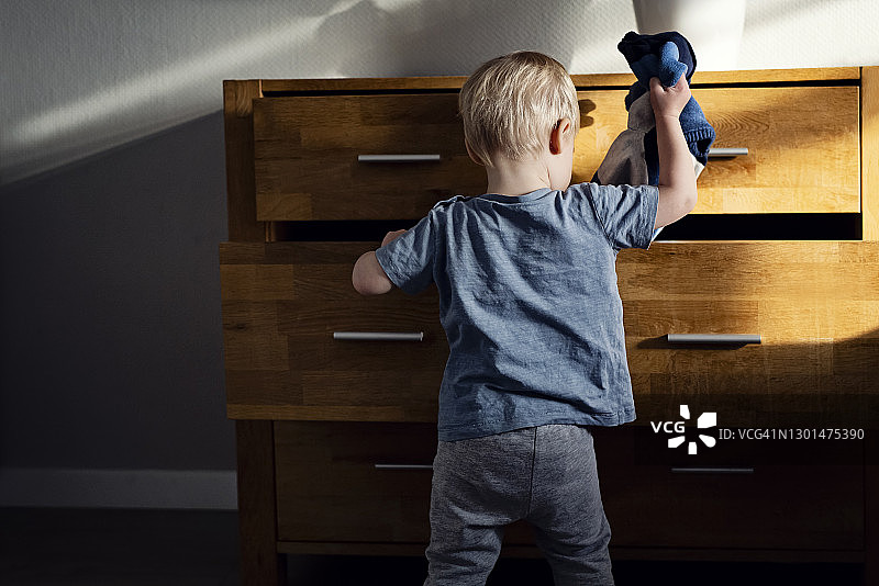 小男孩在挑选衣服图片素材