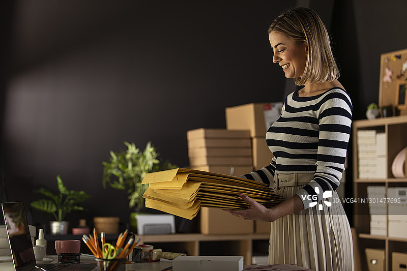 微笑的女企业家拿着黄色信封的抓拍图片素材