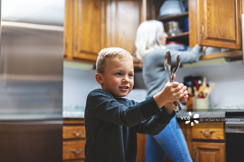 母亲和两个年幼的儿子在厨房共度时光母亲节照片系列图片素材