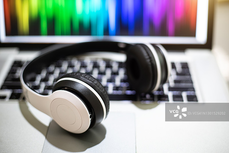 笔记本电脑上的白色耳机，用于电影编辑和媒体图片素材