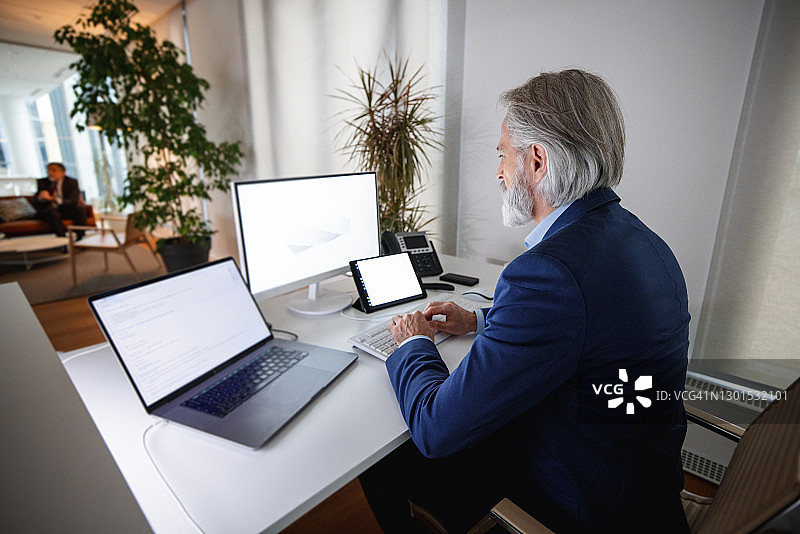 商务人士在办公室分析电脑屏幕上的数据图片素材