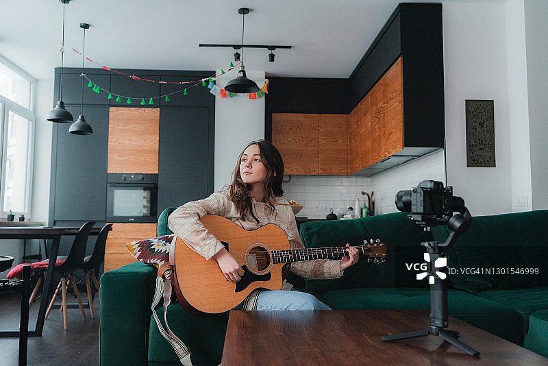 女人拍摄自己弹吉他的视频图片素材