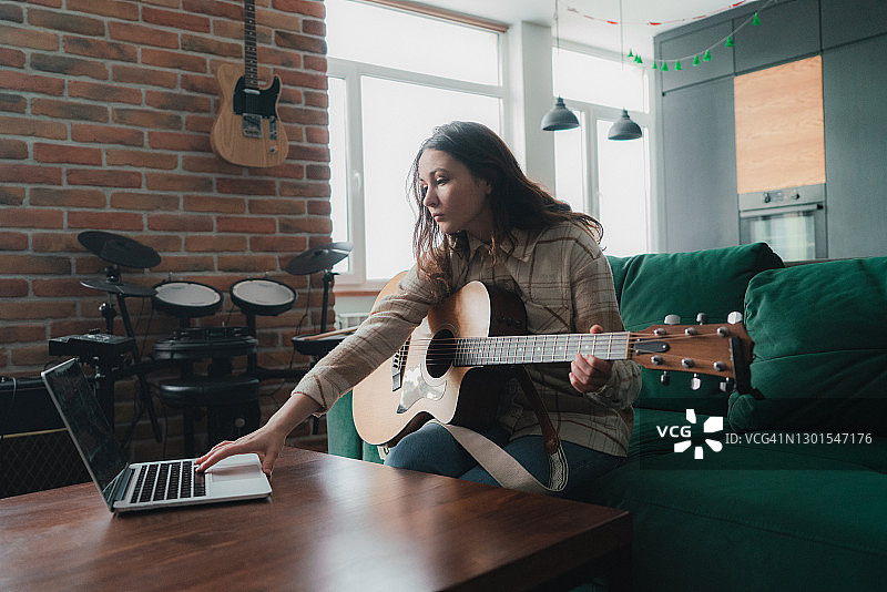 女人观看吉他演奏教学视频图片素材
