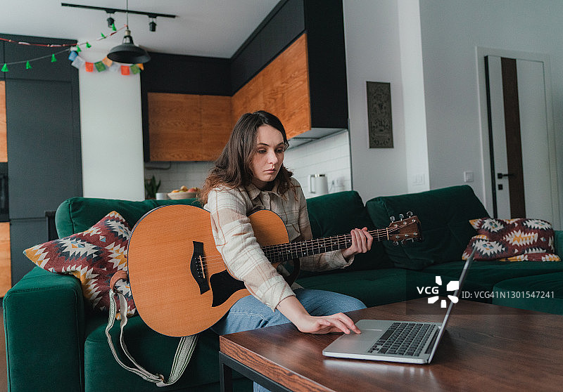 女人观看吉他演奏教学视频图片素材