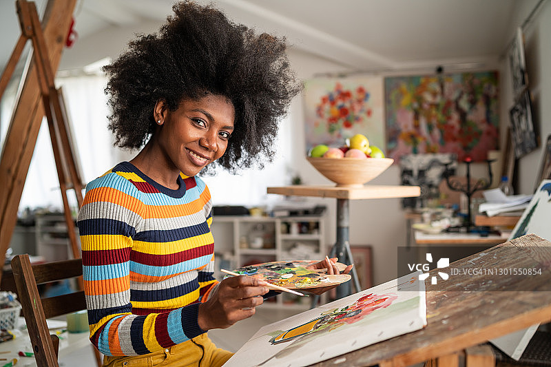 在工作室绘画的非洲裔美术画家，手持调色板图片素材