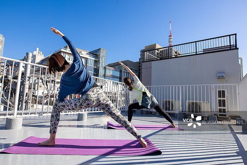 女运动员在屋顶上练习瑜伽图片素材