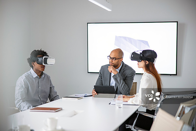 商务人士通过VR头显向同事展示3D模型图片素材