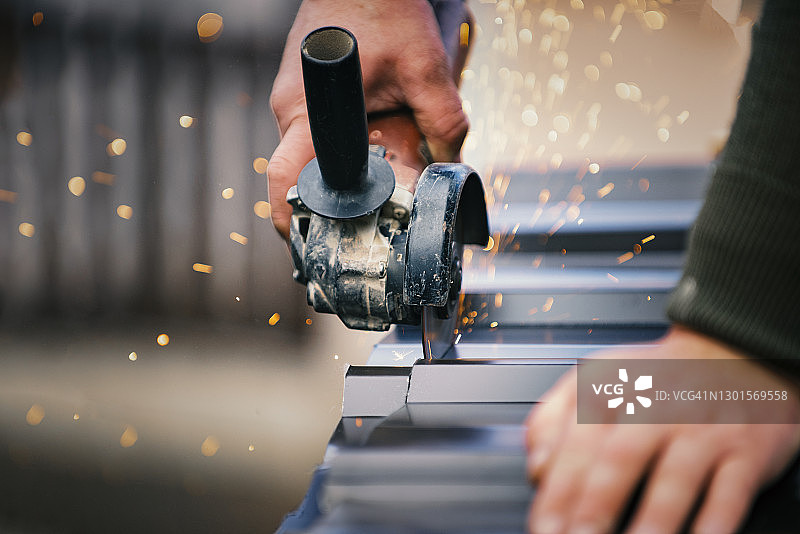 建筑承包商用角磨机切割轻型金属屋顶板图片素材