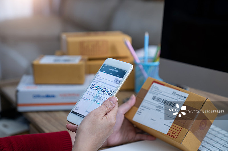 电商货运公司员工用手机扫描条形码图片素材