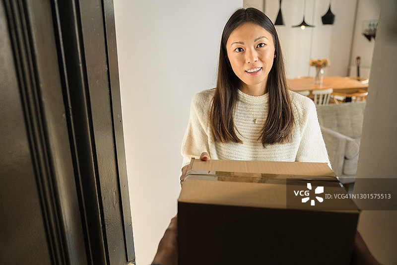年轻女人从快递员手中接收包裹图片素材