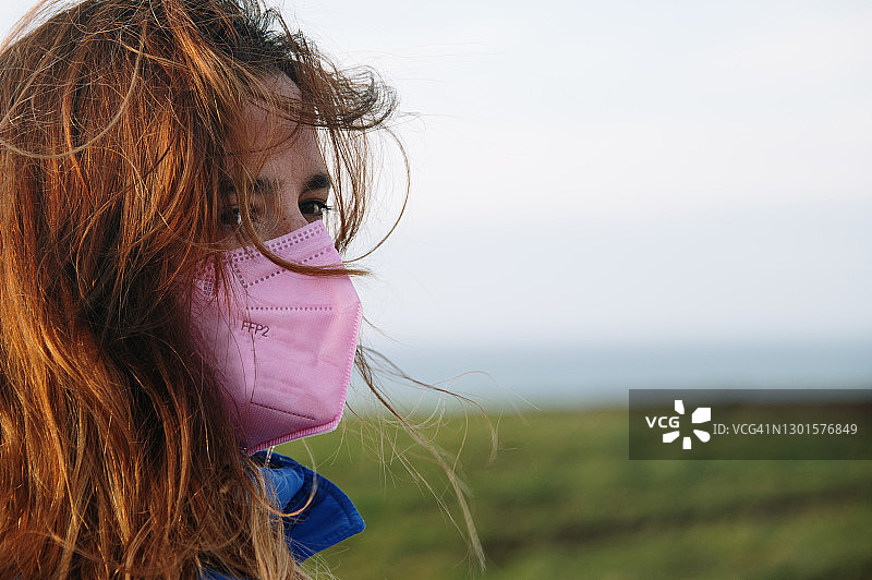 佩戴粉色FFP2口罩的年轻女子特写图片素材