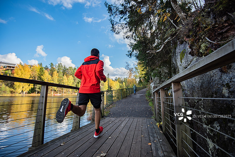 运动男子在自然中的桥上跑步图片素材