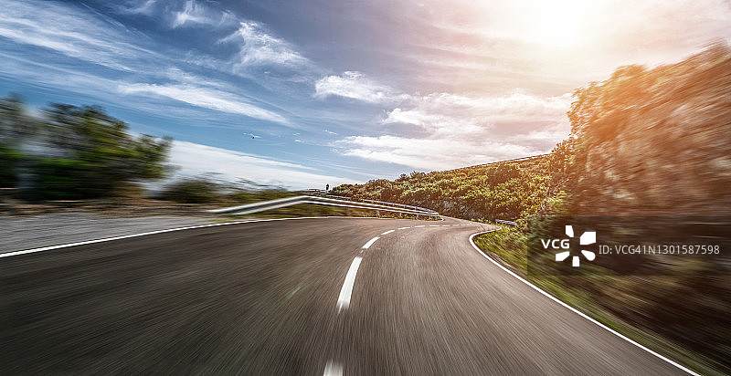 晴朗夏日明媚日落时分的空旷长路图片素材