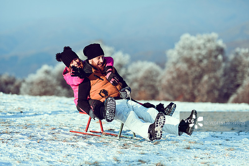 姐弟在雪地上玩雪橇图片素材