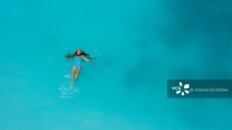 航拍：坦桑尼亚桑给巴尔岛清澈碧绿的海水中独自游泳的女人图片素材