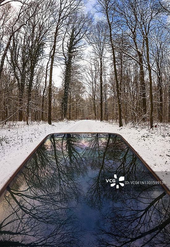 智能手机玻璃上树木和天空的倒影图片素材