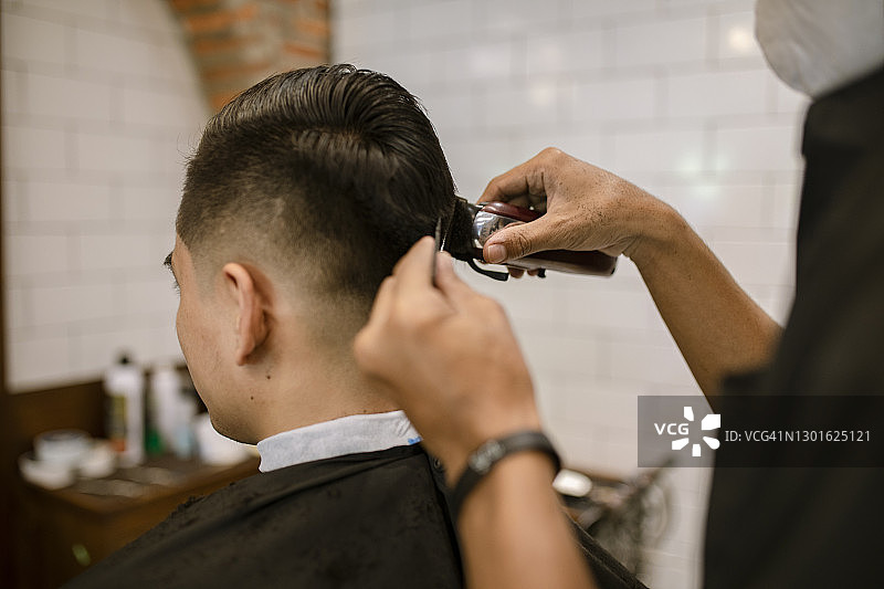 在理发店的年轻亚洲男人图片素材
