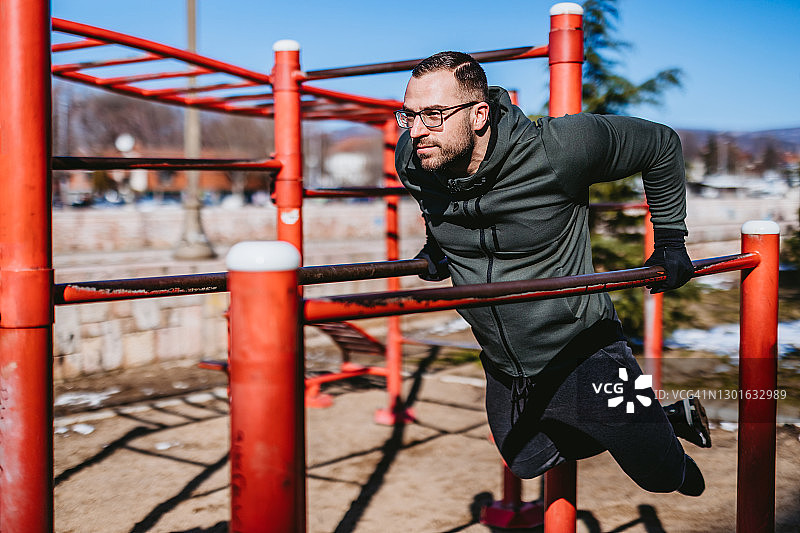 男人在户外做双杠臂屈伸图片素材