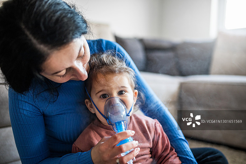 女人和她的女儿使用吸入器图片素材