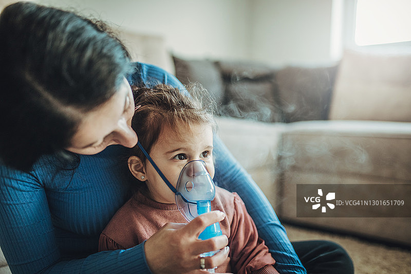 女人和她的女儿使用吸入器图片素材