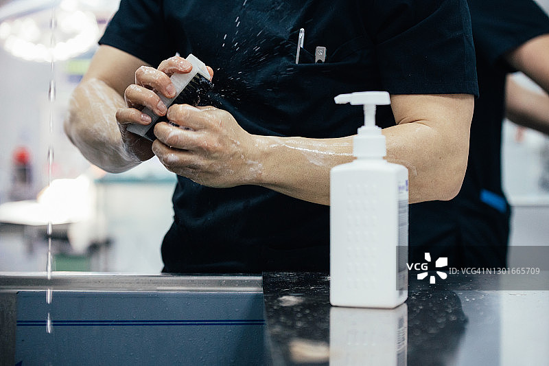 医院内，医生用刷子清洗消毒双手图片素材