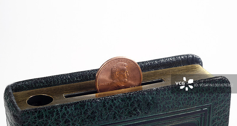 老式图书储蓄罐插槽里的便士图片素材