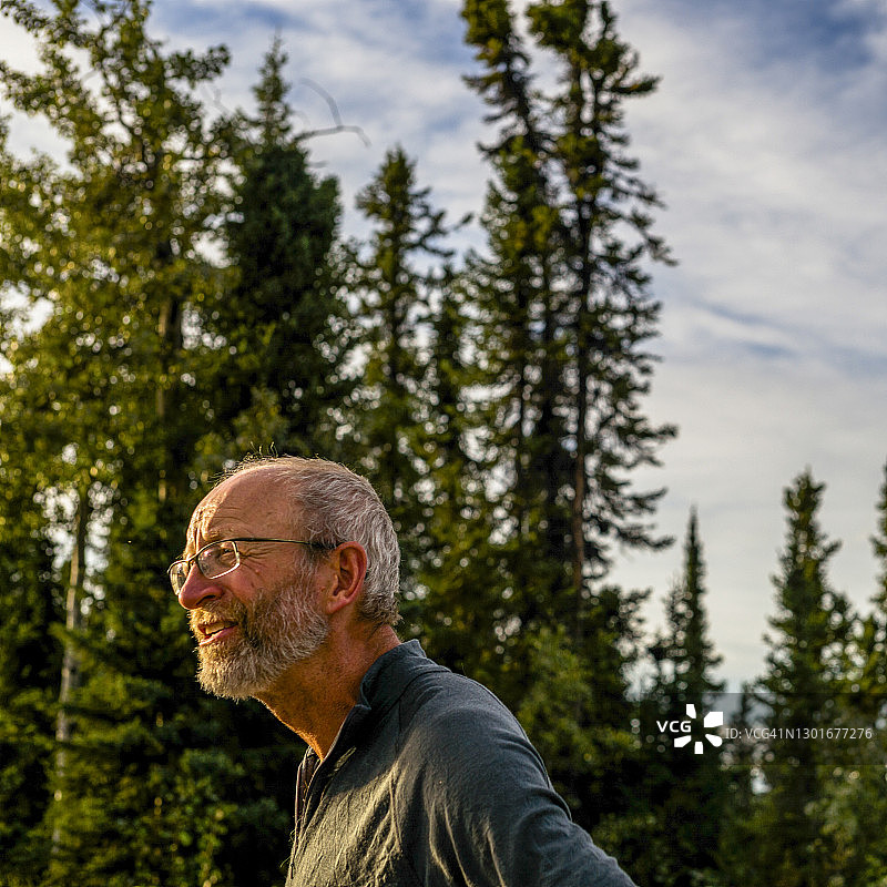 成熟男人清晨徒步穿越森林的肖像图片素材