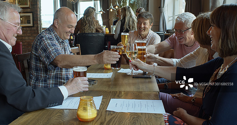 一群快乐的退休朋友在酒吧祝酒图片素材