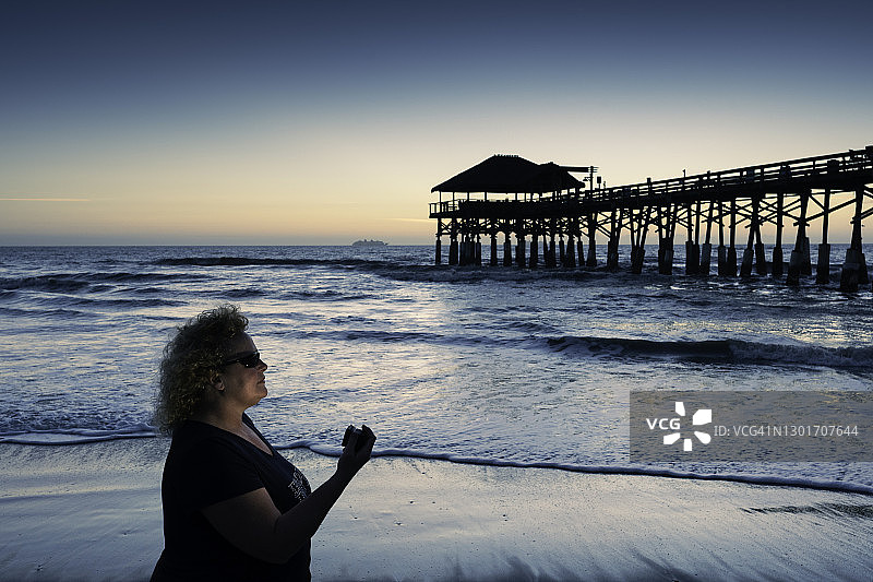 女人在可可海滩码头黎明时分散步图片素材
