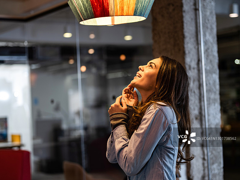 年轻快乐的女人欣赏吊灯图片素材