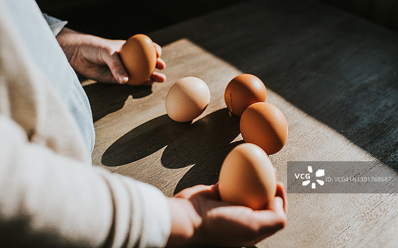 儿童拿着5个鸡蛋中的2个图片素材