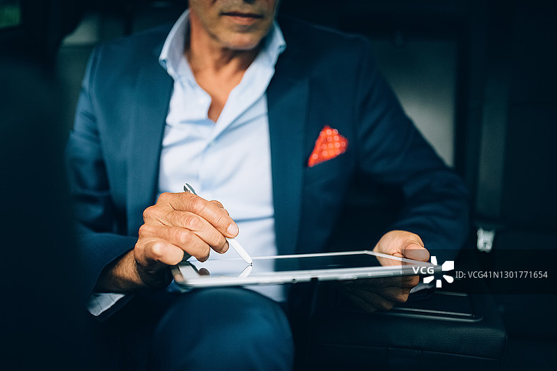 在出租车上使用平板电脑的商人图片素材