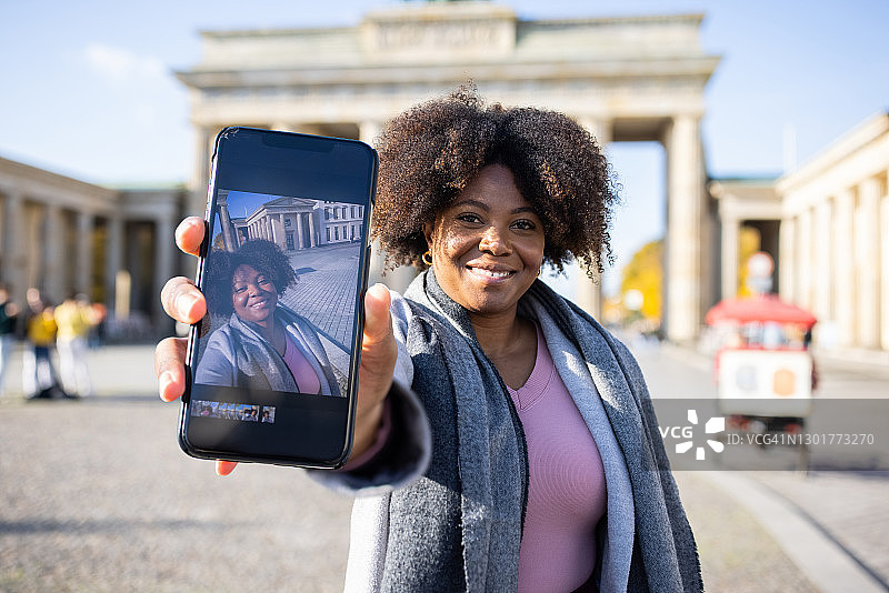 非洲女人在手机上展示她的照片图片素材