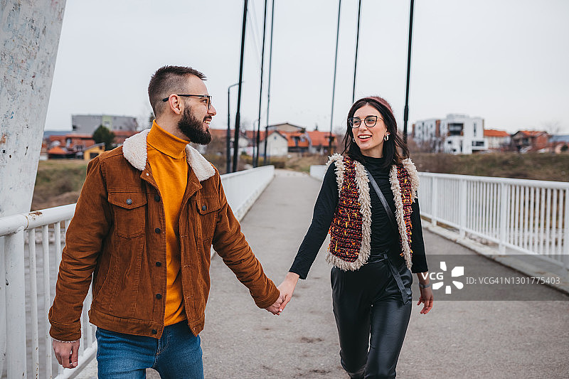 男友牵着女友的手在小路上玩耍图片素材