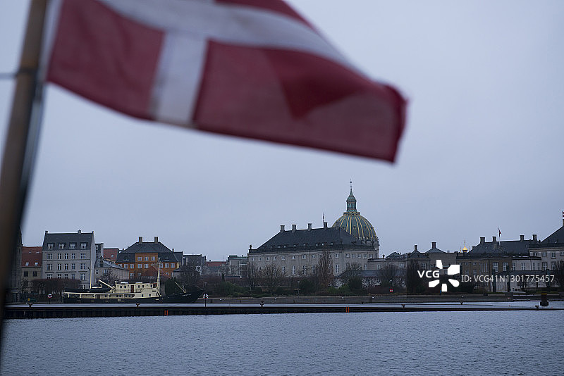哥本哈根天际线上方升起的腓特烈教堂大圆顶与丹麦国旗图片素材