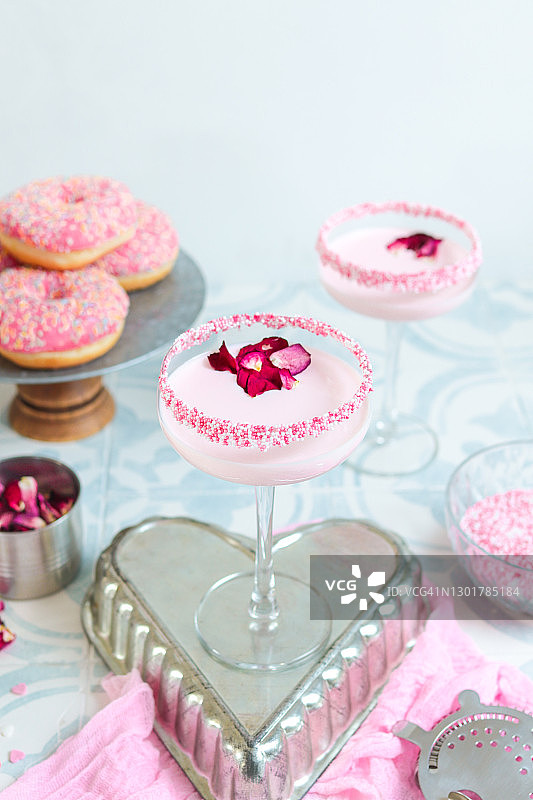 粉色草莓奶油鸡尾酒，含糖屑和玫瑰花瓣图片素材