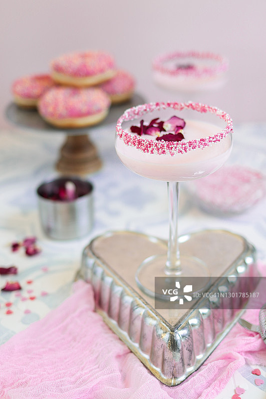 粉色草莓奶油鸡尾酒，含糖屑和玫瑰花瓣图片素材