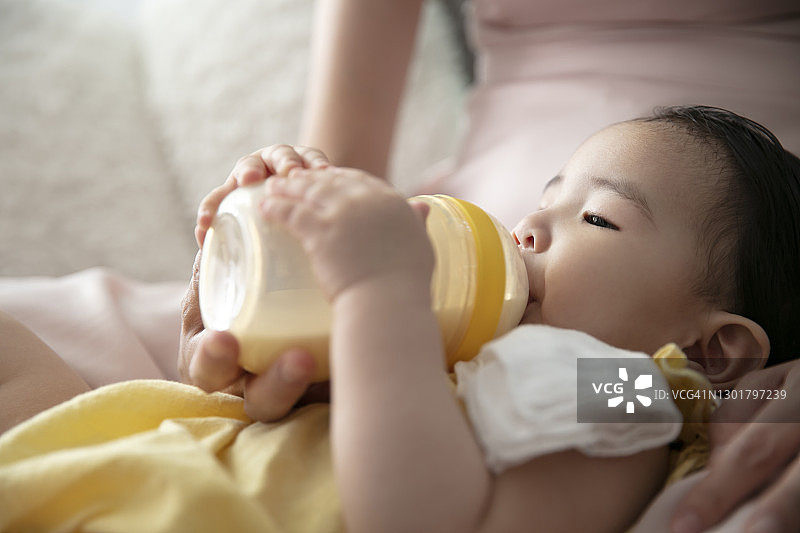 母亲用奶瓶喂新生婴儿图片素材