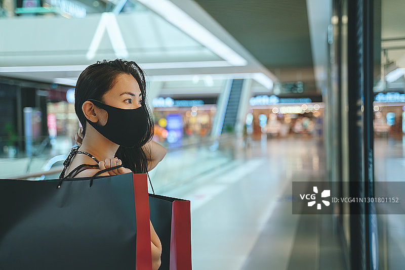 戴防护口罩购物：新常态图片素材