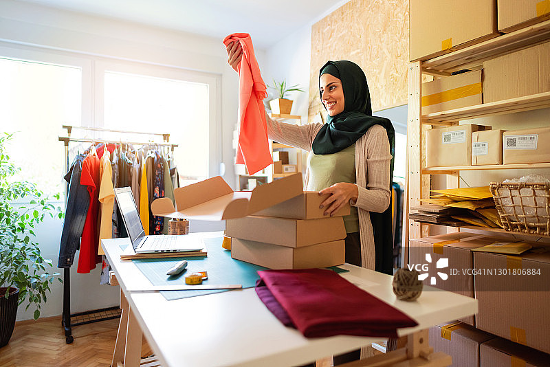 笑容满面的女子在一家小型本地商店工作图片素材